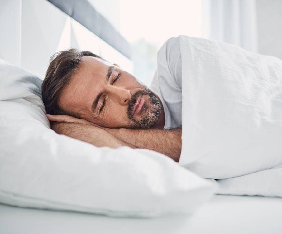 Man slaapt in eigen bed voor slaaponderzoek en slaap positie training