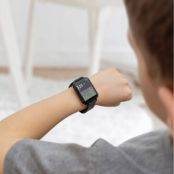 Jongen checkt glucosesensor op smartwatch