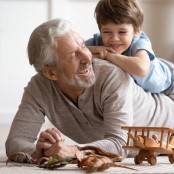 Opa speelt met kleinzoon op de grond