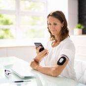 Vrouw controleert glucosewaarde via een sensor