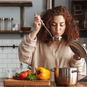 Vrouw proeft eten tijdens koken