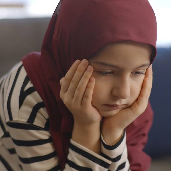 Meisje met hoofddoek met hoofd in handen