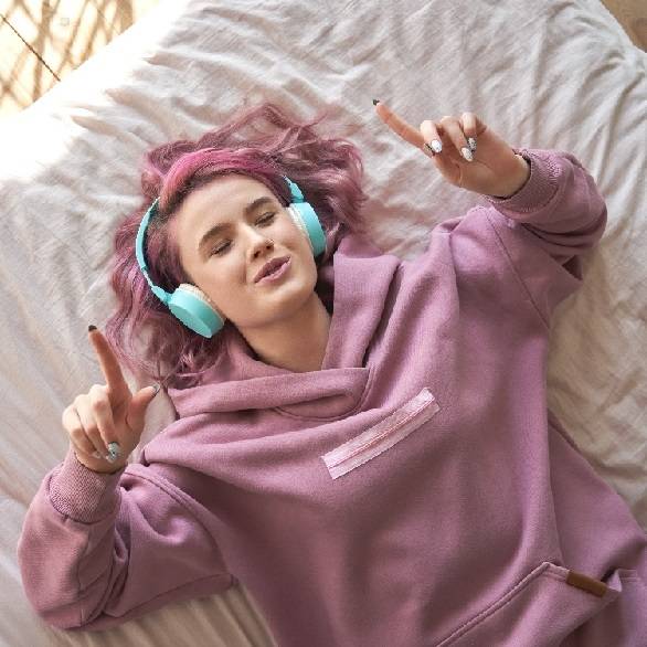 Tiener op bed luistert naar muziek