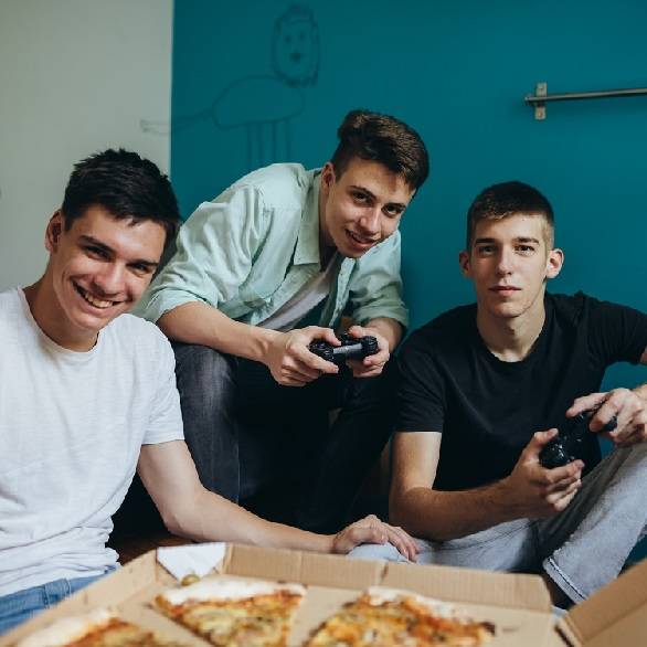 Tieners gamen en eten pizza