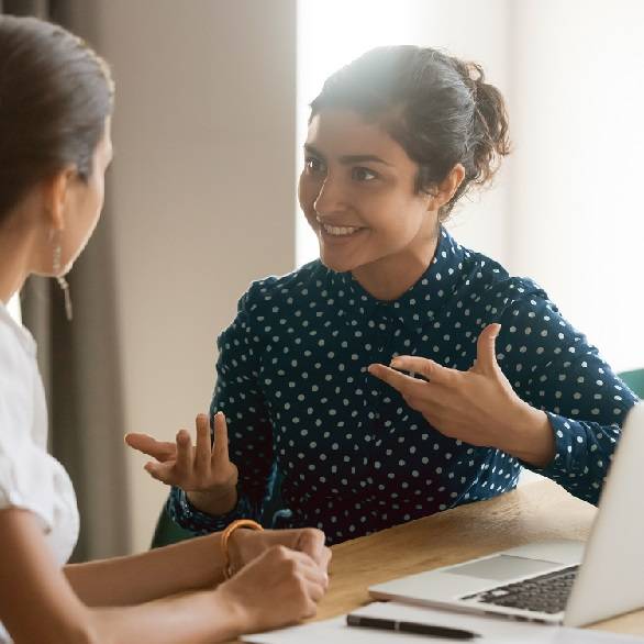 Vrouw krijgt uitleg achter laptop