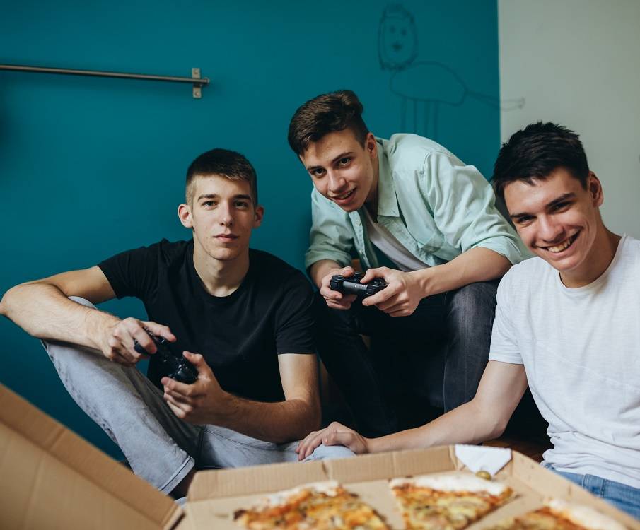 Tieners gamen en eten pizza