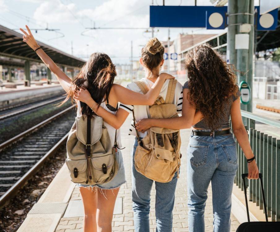 Drie jonge vrouwen gaan op vakantie vanaf een treinstation