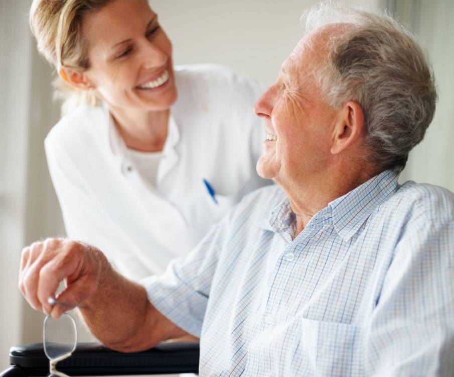 Verpleegkundige helpt oudere patient in verzorgingstehuis