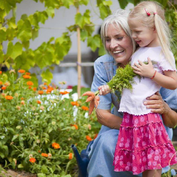 Oudere vrouw met kind in tuin