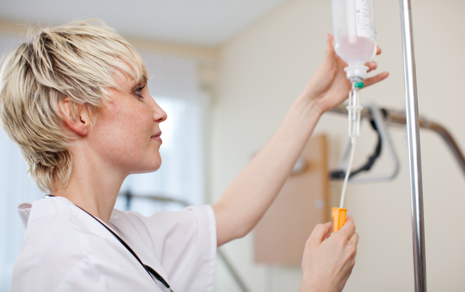 Verpleegkundige controleert de doorloop van medicatie via een infuus