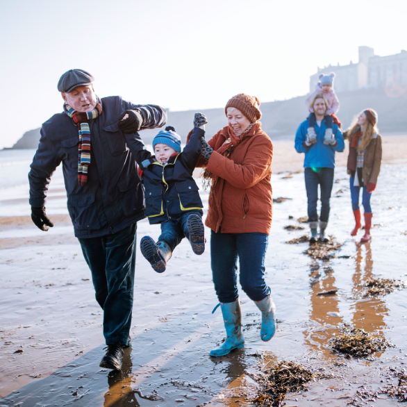 Familie wandelt langs het strand