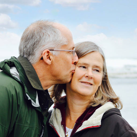 Ouder echtpaar wandelt over het strand en toont affectie