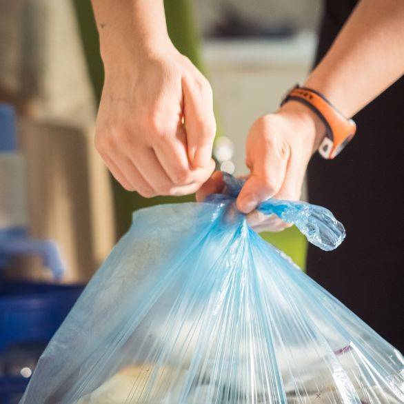 Man maakt vuilniszak dicht