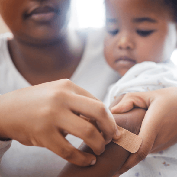 Moeder plakt een pleister bij een kind