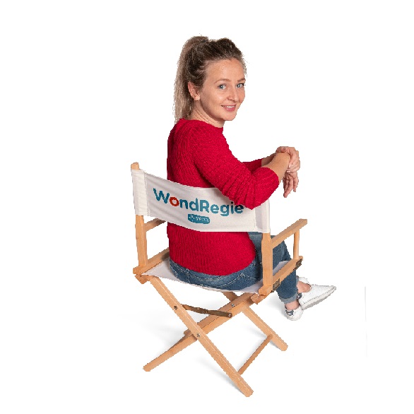 Dame in rood shirt zit op wondregie stoel