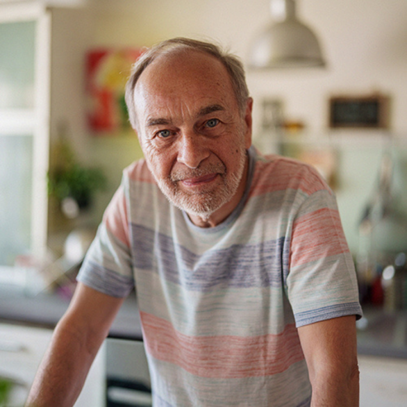 Een man leunt met zijn armen op tafel en lacht