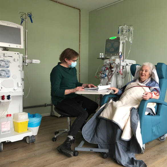 Patiënt wordt gedialyseerd en begeleid door een verpleegkundige van Thuisziekenhuis Nederland in een dialysehub in Ametisthorst