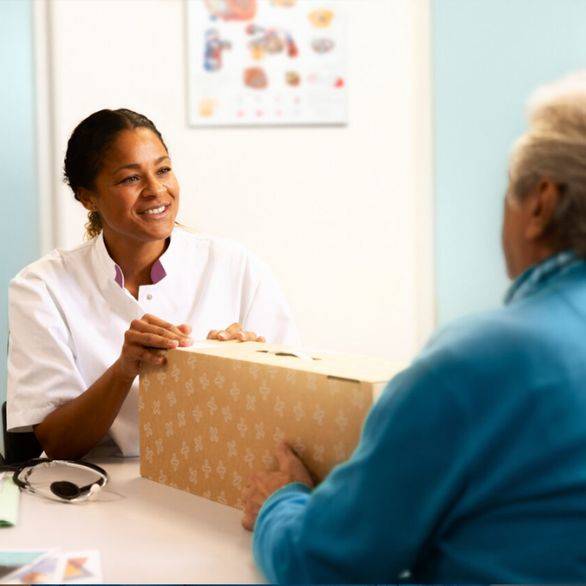 Zorgprofessional geeft patiënt startset voor incontinentie